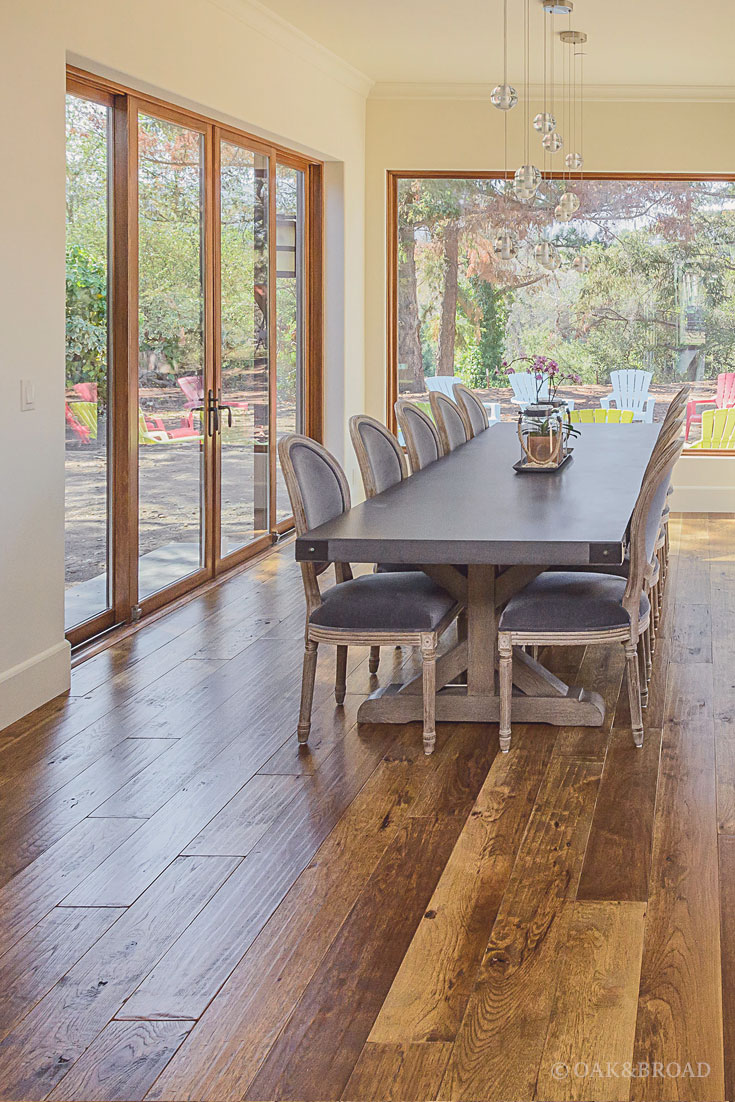 Wide Plank Hand-Scraped Hickory Hardwood Floor by Oak and Broad | Dining area with huge farm table and floor to ceiling windows