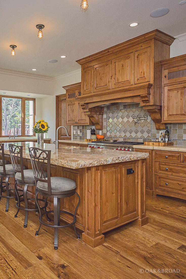 Wide Plank Hand-Scraped Hickory Hardwood Floor by Oak and Broad | kitchen with diamond tile backsplash and rich, warm details