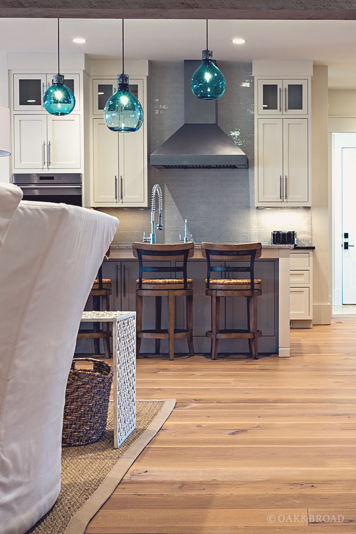 Wide Plank White Oak Hardwood Floor by Oak and Broad with Custom Stain | Charming green glass pendant lights over custom floor in rustic modern kitchen