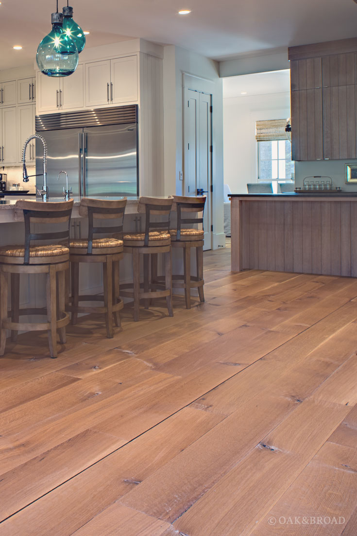 Wide Plank White Oak Hardwood Floor by Oak and Broad with Custom Stain | Rustic modern kitchen with charming bar stools and wood island