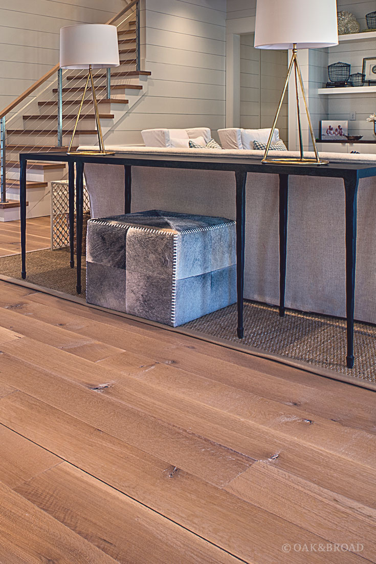 Wide Plank White Oak Hardwood Floor by Oak and Broad with Custom Stain | Rustic modern living room with cowhide ottoman detail