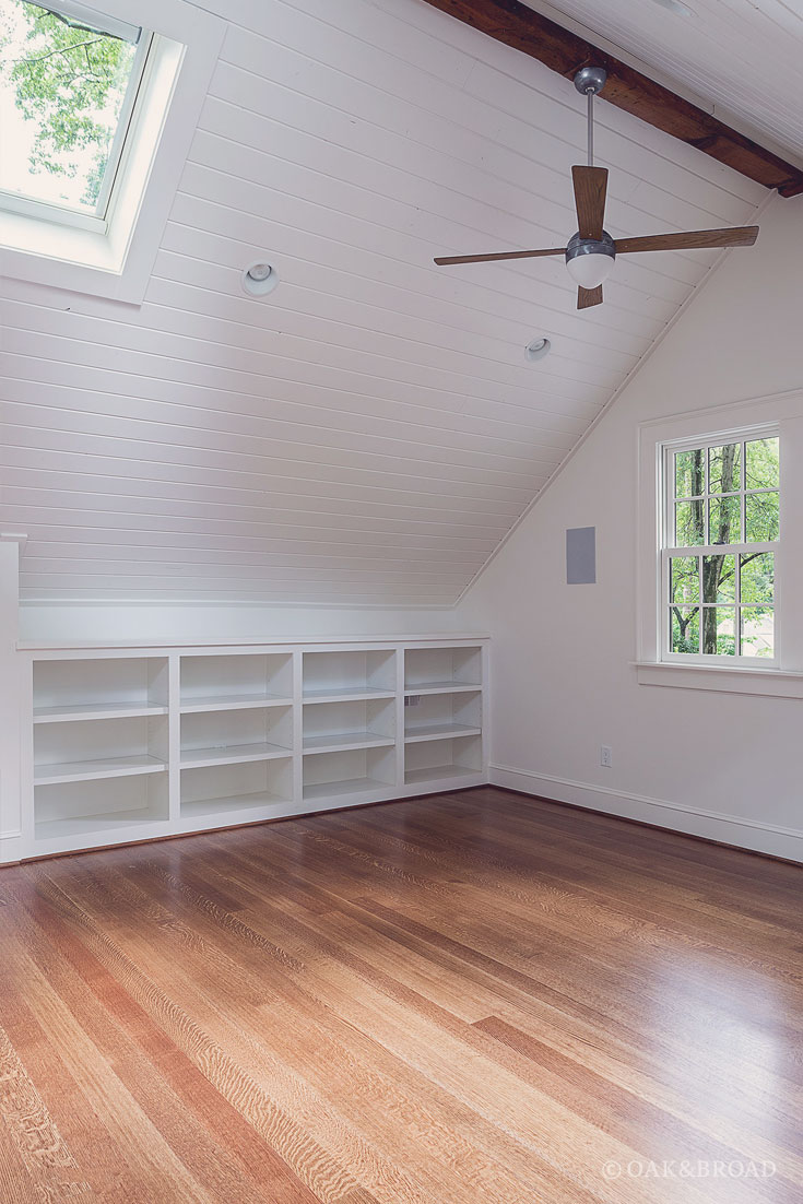 Wide Plank White Oak Floor By Oak And Broad | Select & Better Rift & Quartered | Room with slanted ceiling and built-in shelves