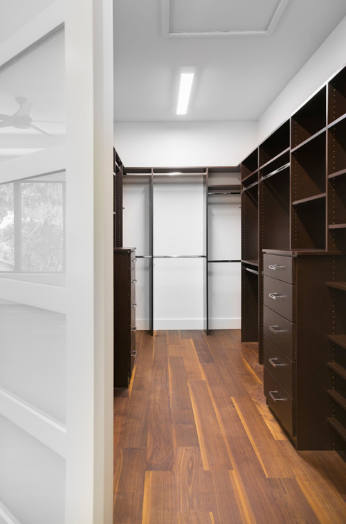Closet in modern home with black walnut wide plank floor by Oak & Broad